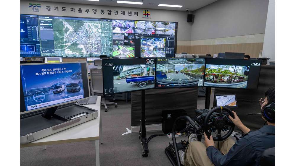 An operator at the remote-driving station in front of several screens