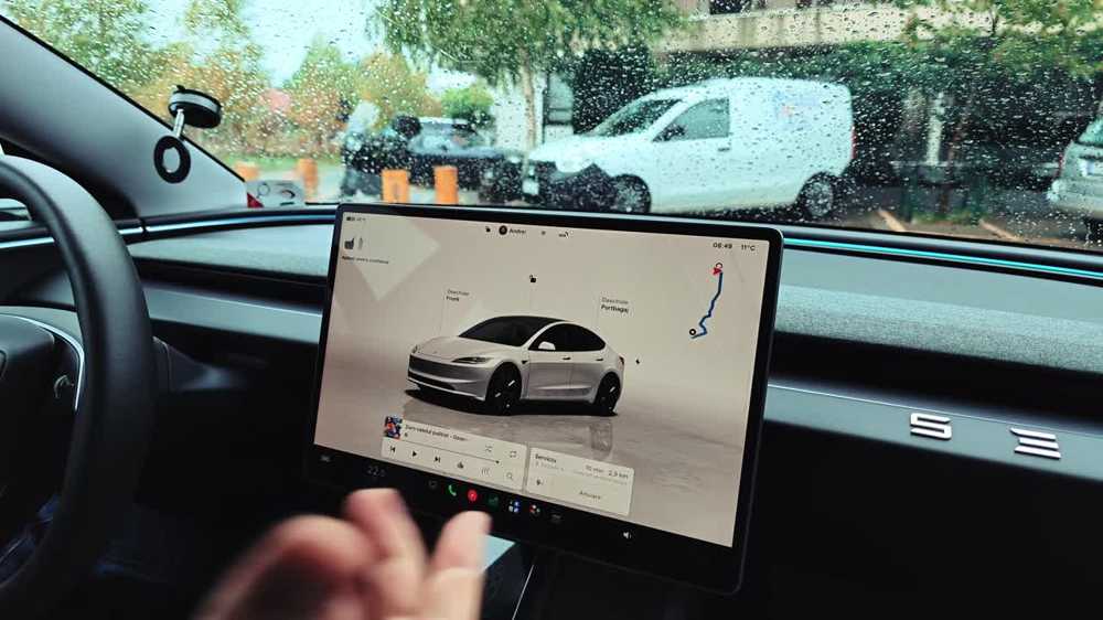 Andrei at the wheel of a Tesla Model 3, explaining the on-screen alerts