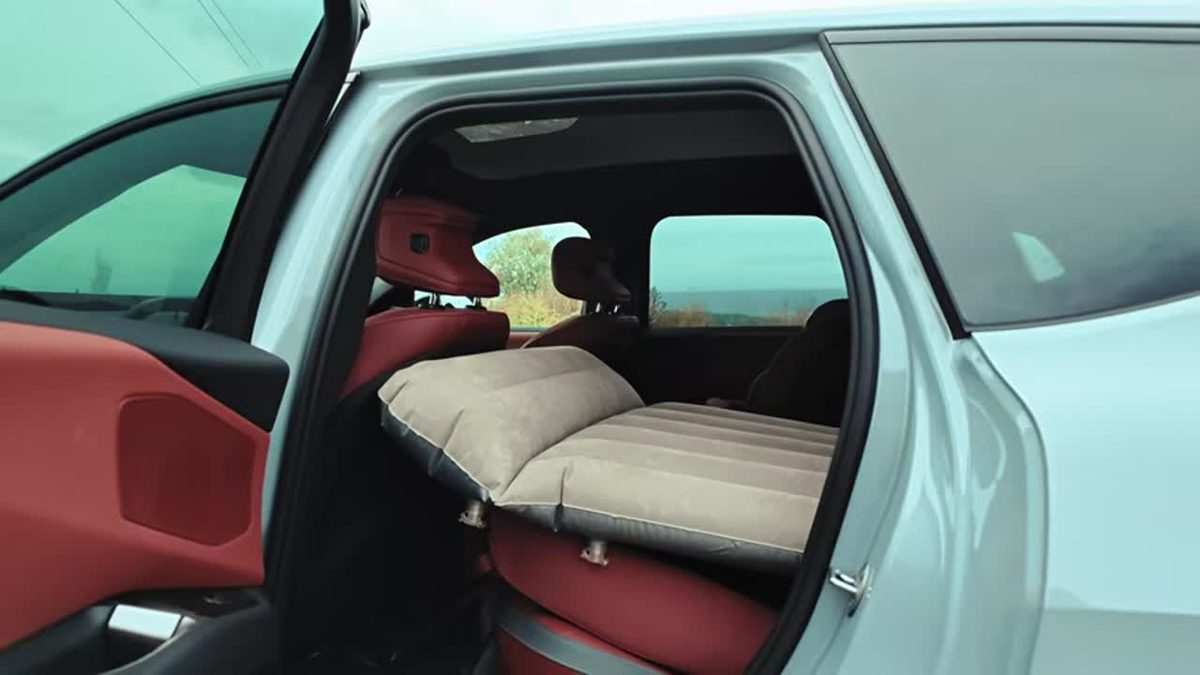 Inflatable mattress set up across the folded rear seats of a BMW iX3 40
