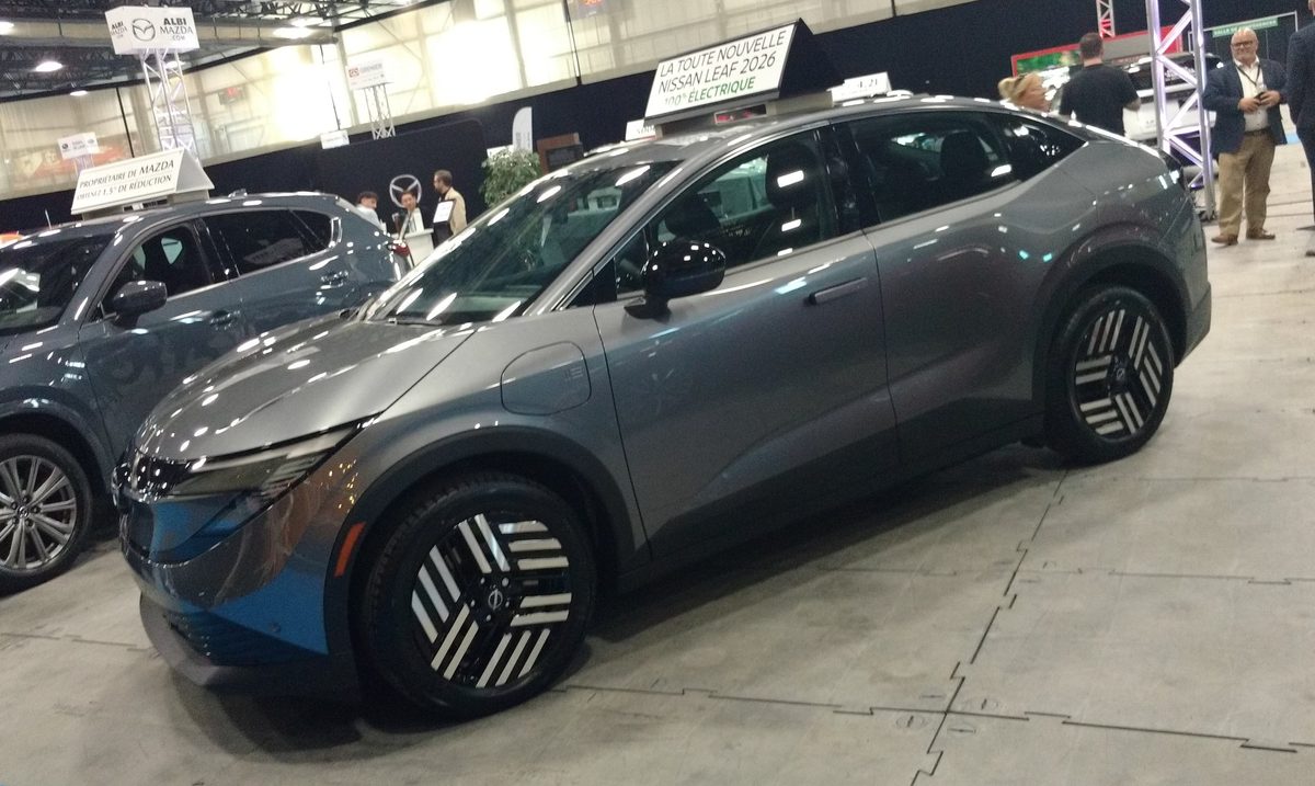 Grey 2026 Nissan Leaf on display at an auto show in Québec, the technical twin of the Mitsubishi Eclipse Sportback EV