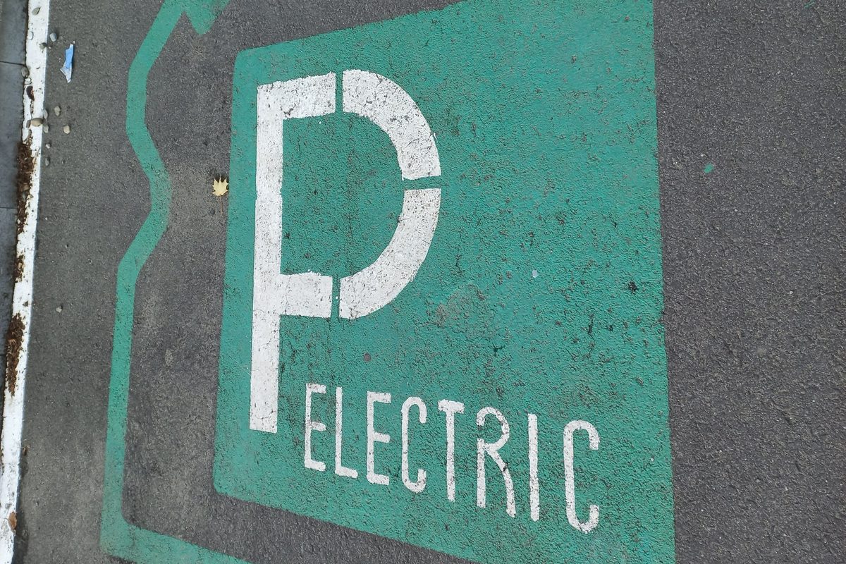 Green-painted EV parking bay with a large P and the word ELECTRIC, in a car park in Sibiu, Romania
