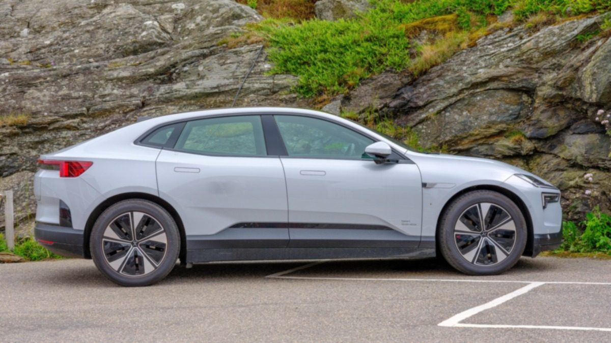 Silver Polestar 4 seen from the side, parked next to a rock wall