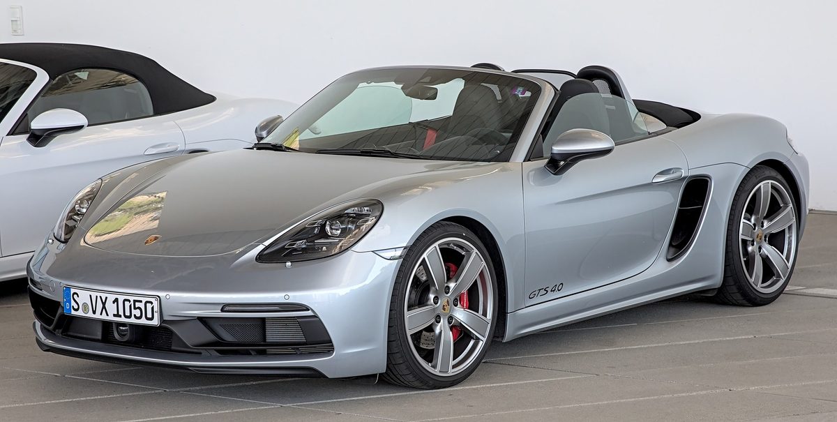 Porsche 718 Boxster GTS 4.0 argintiu, decapotat, văzut din față într-o expoziție