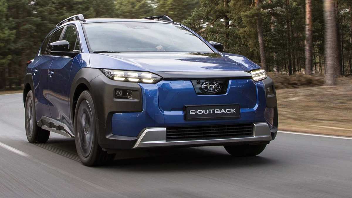Subaru E-Outback albastru, 100% electric, în mers pe un drum printre pini