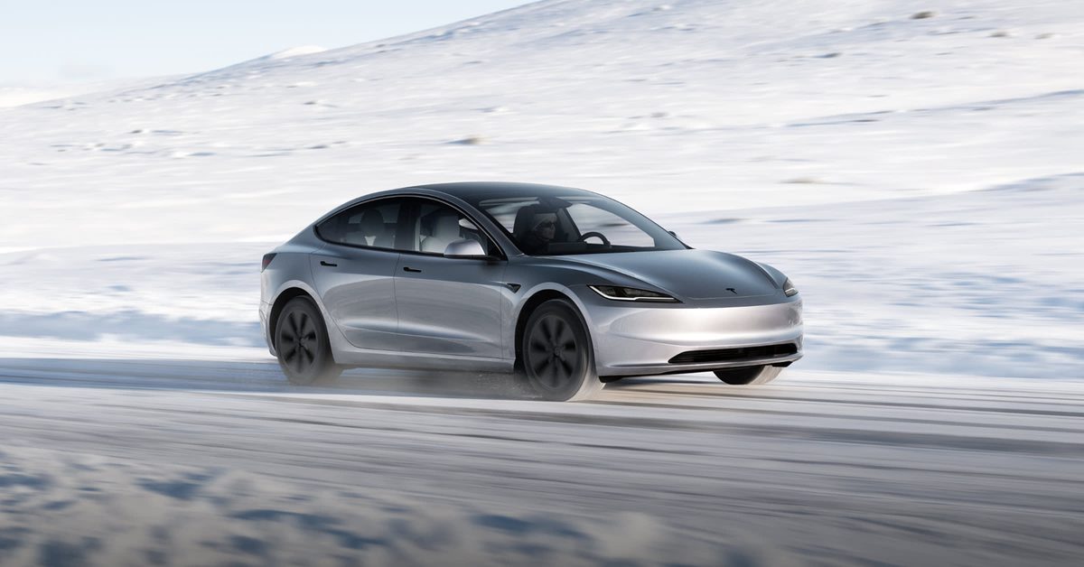 Tesla Model 3 argintie pe un drum acoperit de zăpadă