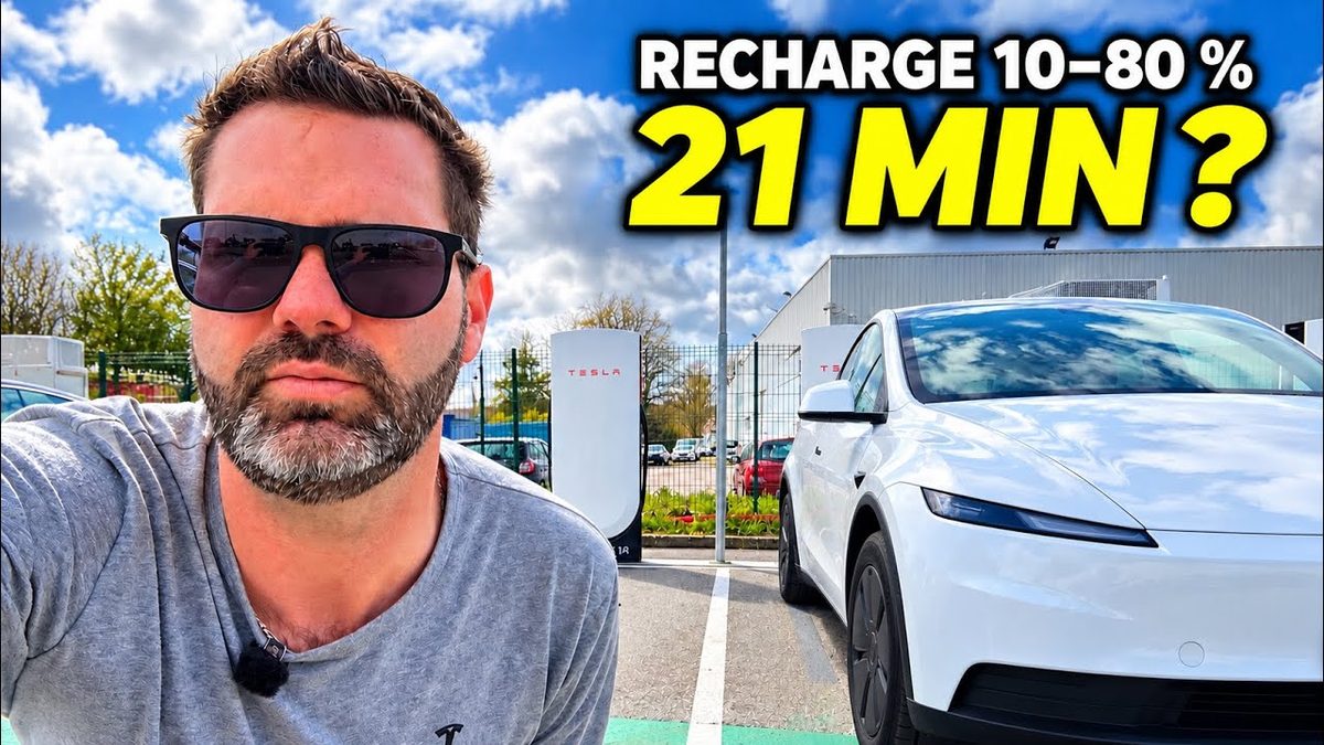 Yoann, autorul canalului Yoann en VE, lângă o Tesla Model Y albă parcată la un Supercharger, cu textul „Recharge 10–80 % 21 min ?”