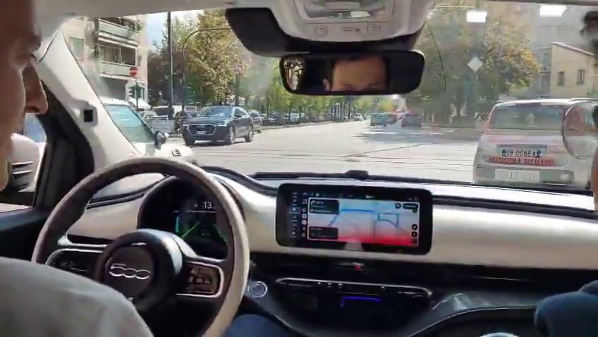 Inside a Fiat 500e development car with Wayve AI Driver, driving hands-free along a Turin avenue